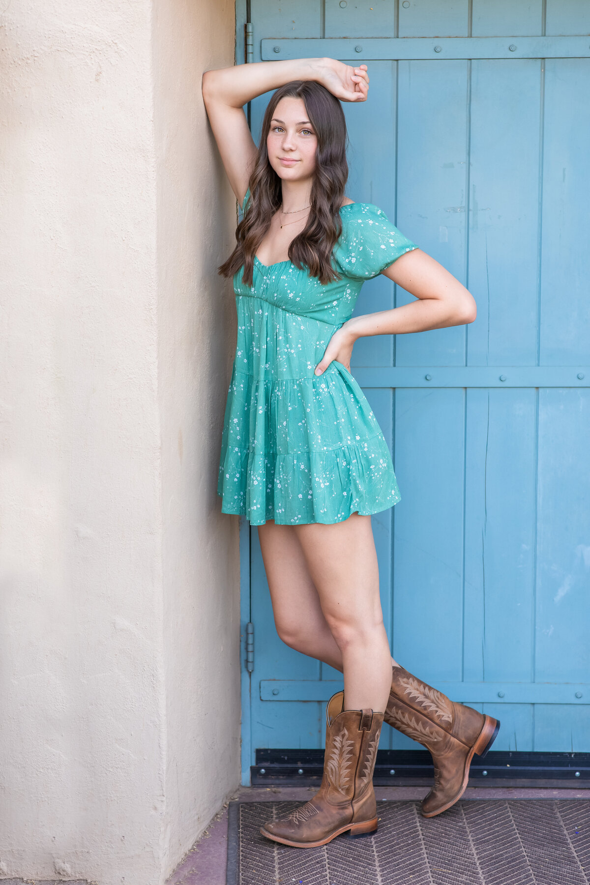 Senior girl in dress and cowboy boots with blue door Popago Park, AZ