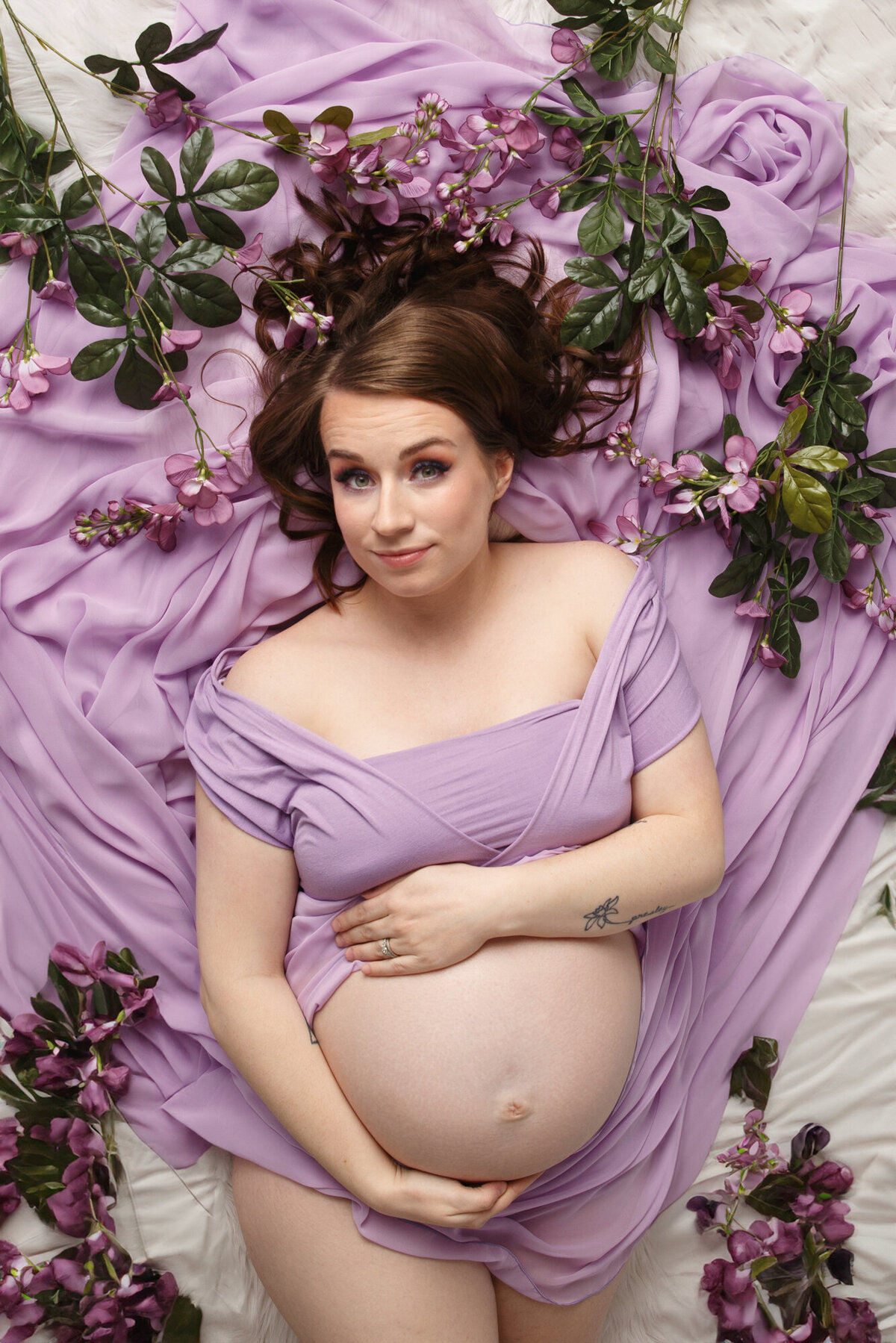 Pregnancy Portrait of a woman wrapped in a lavendar fabric with purple flowers
