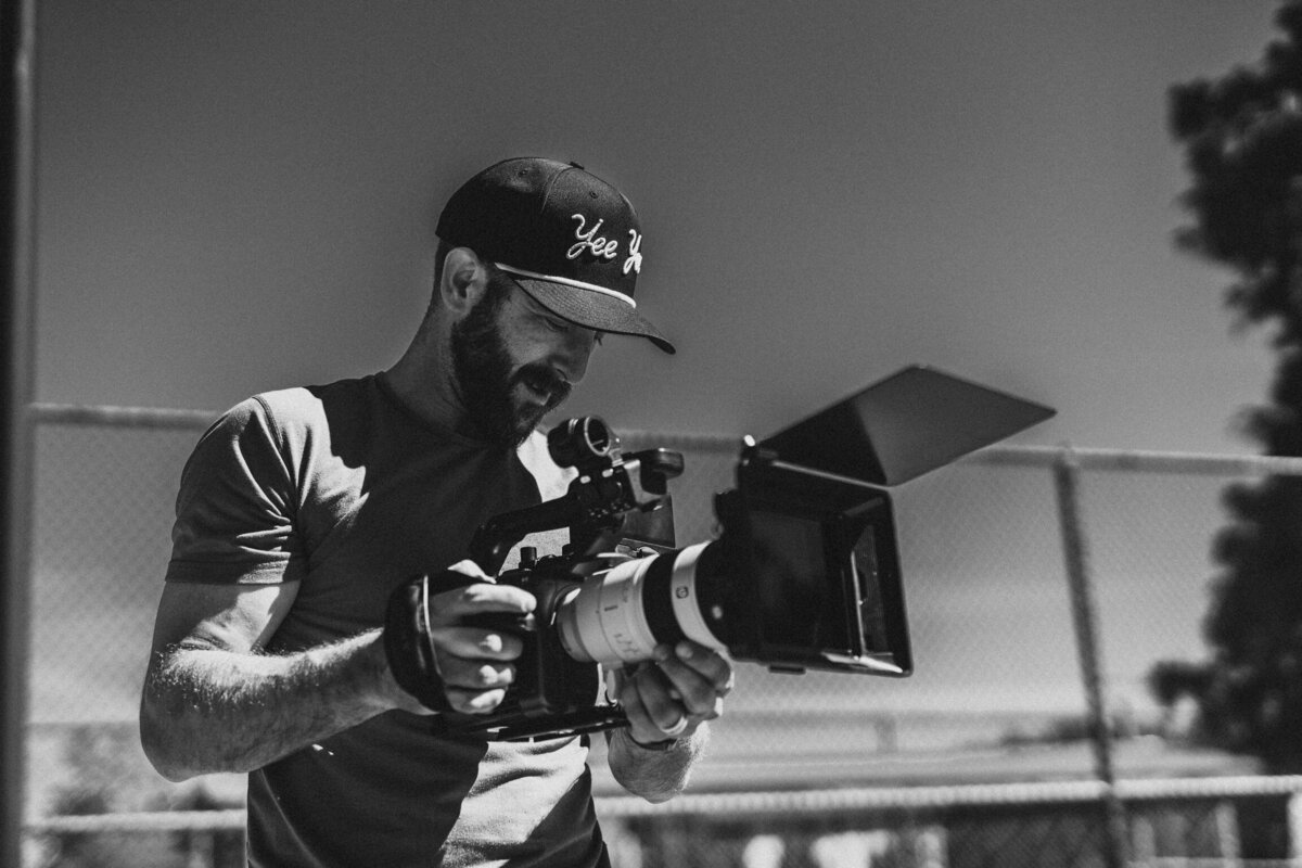 A close-up of a videographer carefully adjusting the focus on a camera, preparing to capture a scene. This image showcases the precision and creativity involved in video ad creation at Future Fox Media, Denver, Colorado.