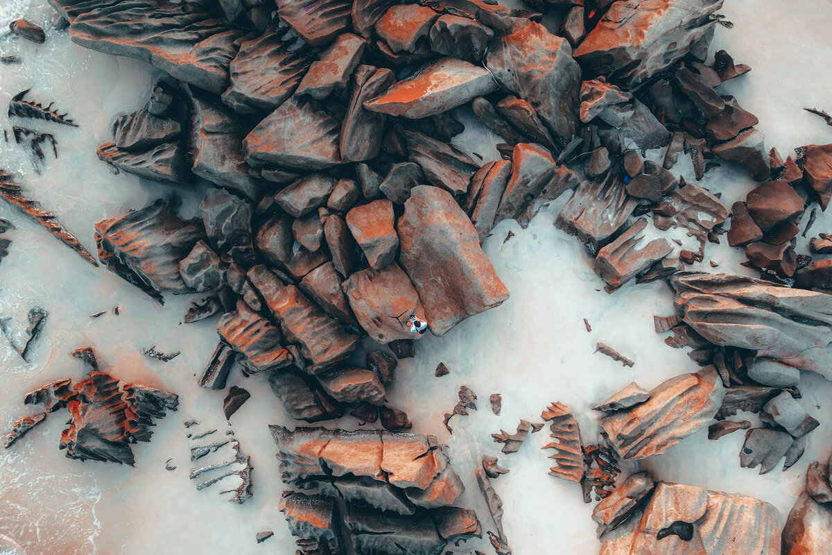 Orange and grey rocks on a beach, symbolizing strength, resilience, and financial empowerment. Ataraxis Financial supports innovative risk-takers, go-getters, and adventurous entrepreneurs in achieving financial clarity and business success. Go after your dreams—book your free consult today!