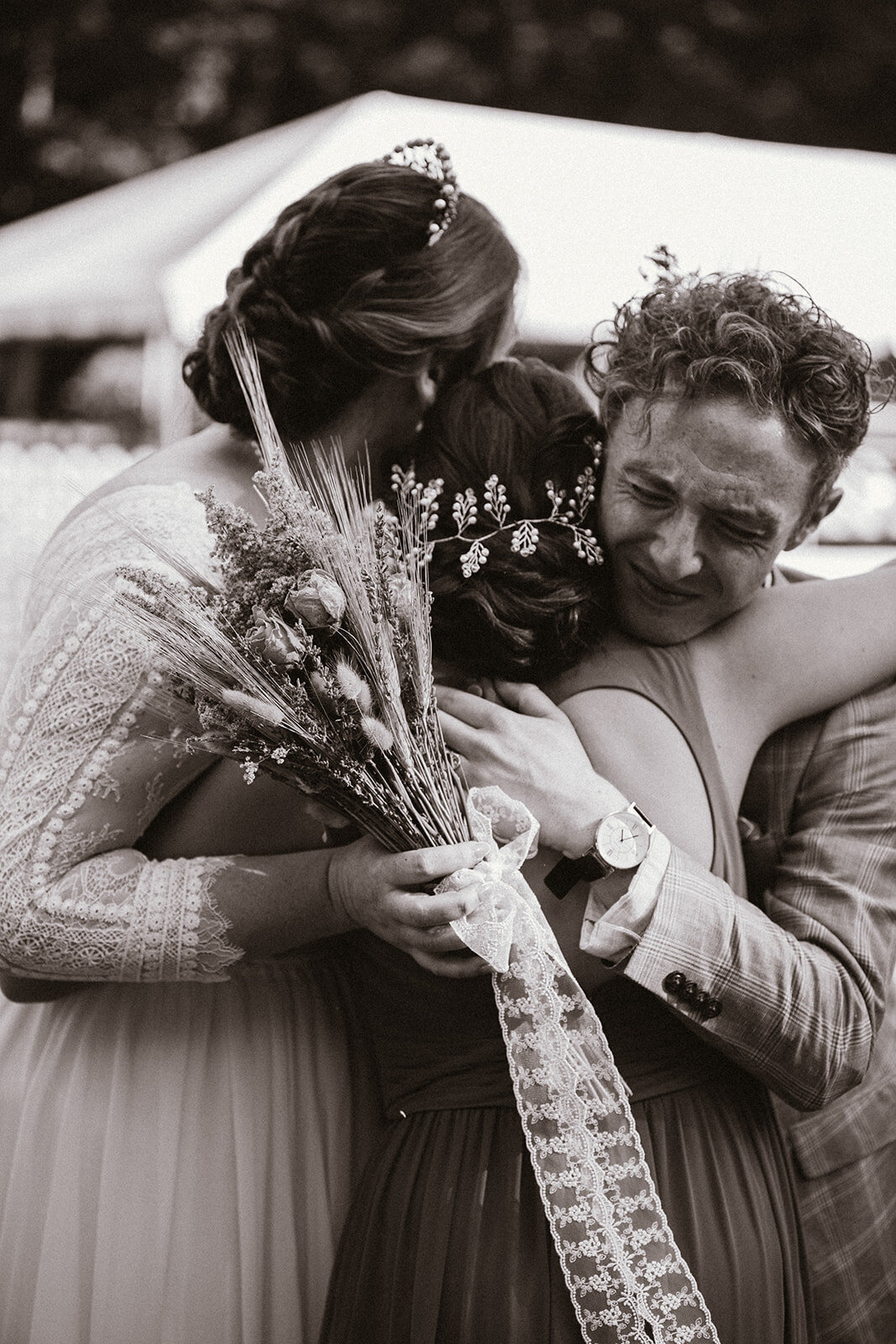 black and white photo of couple hugging their sister