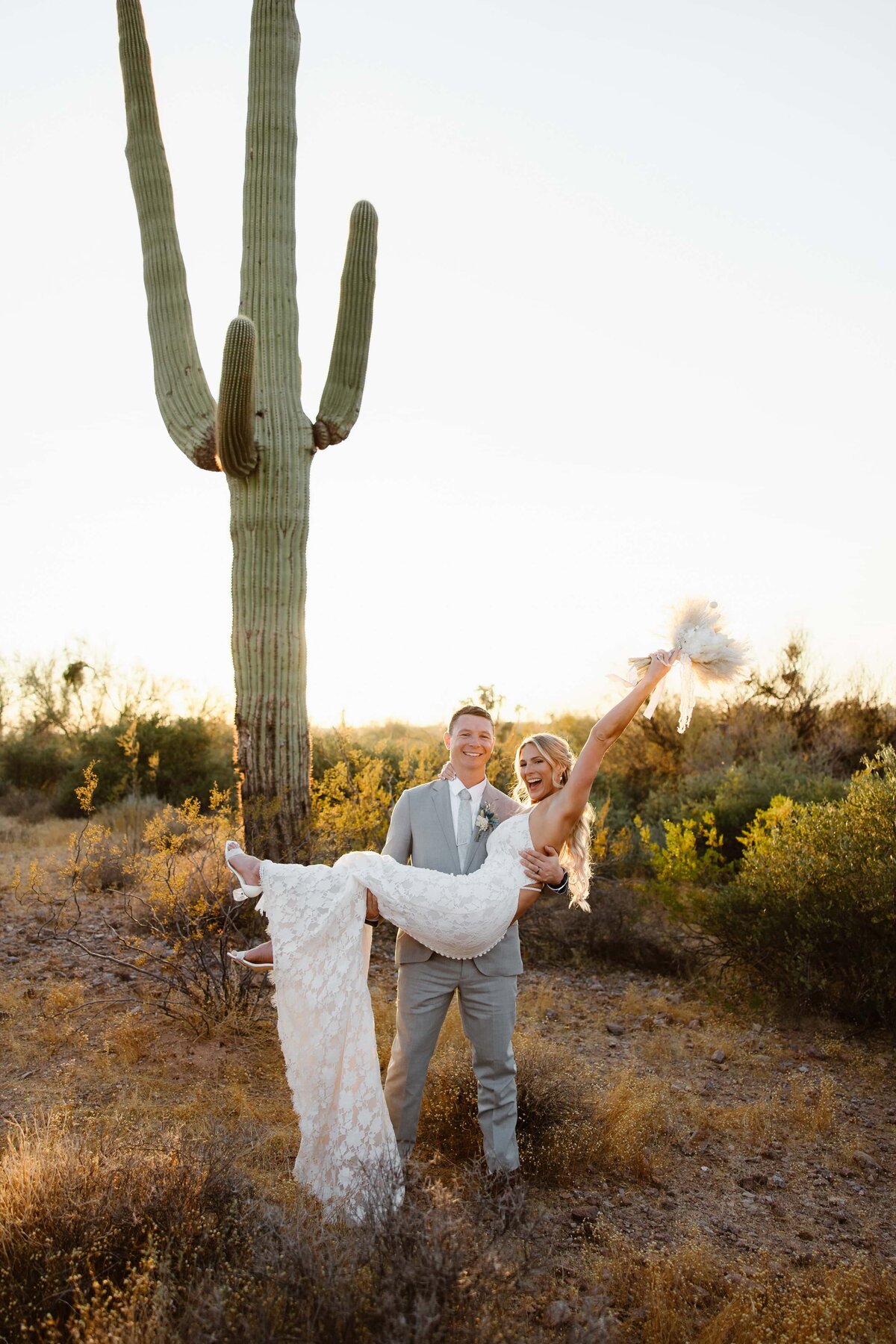 A groom holds his bride as she celebrates their wedding in Phoenix, Arizona.