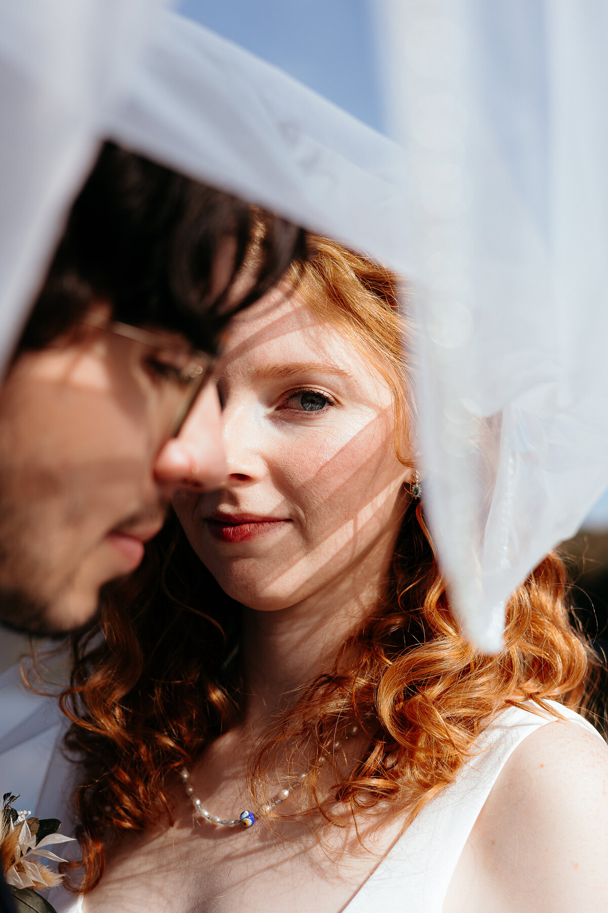 Interracial couple at their elopement. Close up veil photo.