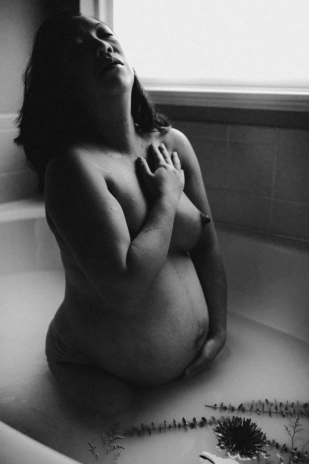 black and white image pregnant woman sitting in bath tub