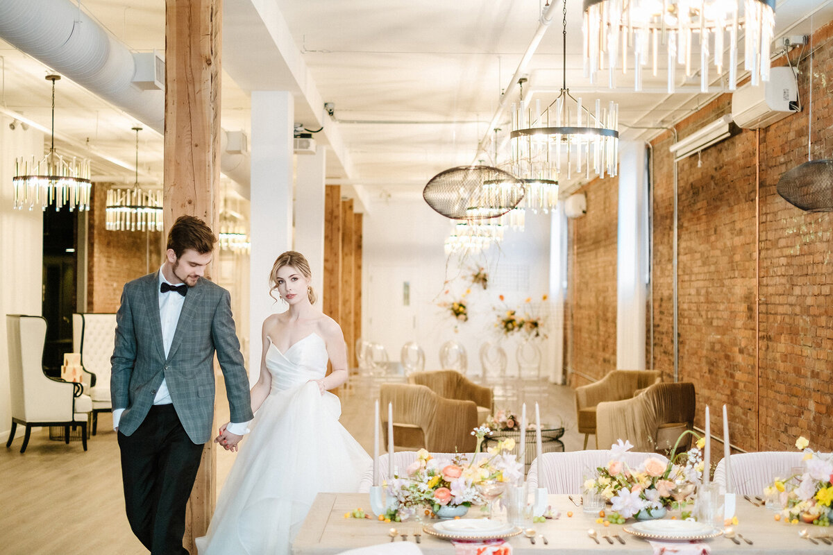 Bride and groom walking through their reception venue with rentals from Modern Rentals, contemporary decor rentals based in Calgary, AB. Featured on the Brontë Bride Vendor Guide.