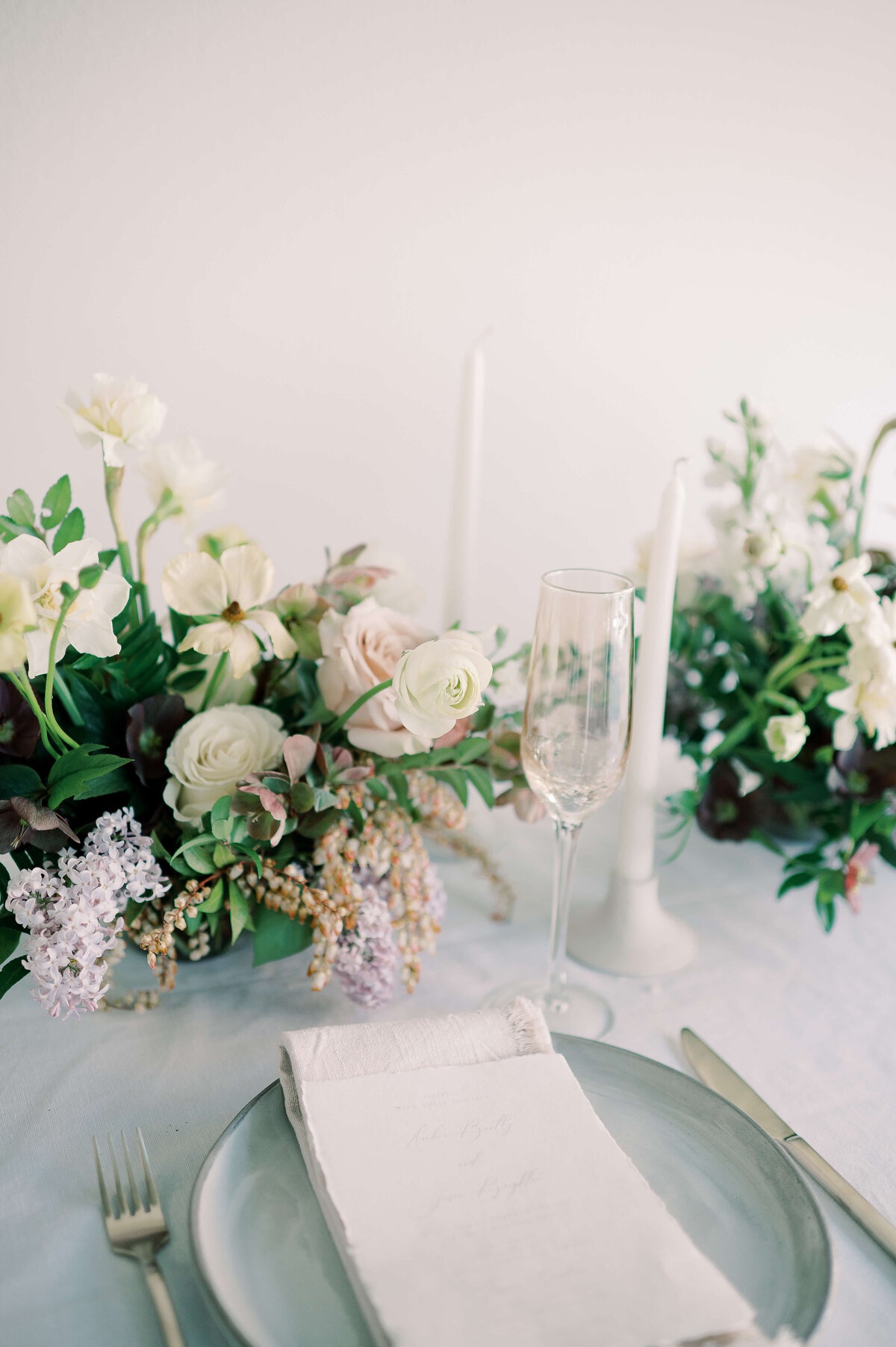 place setting with simple white napkin and floral display