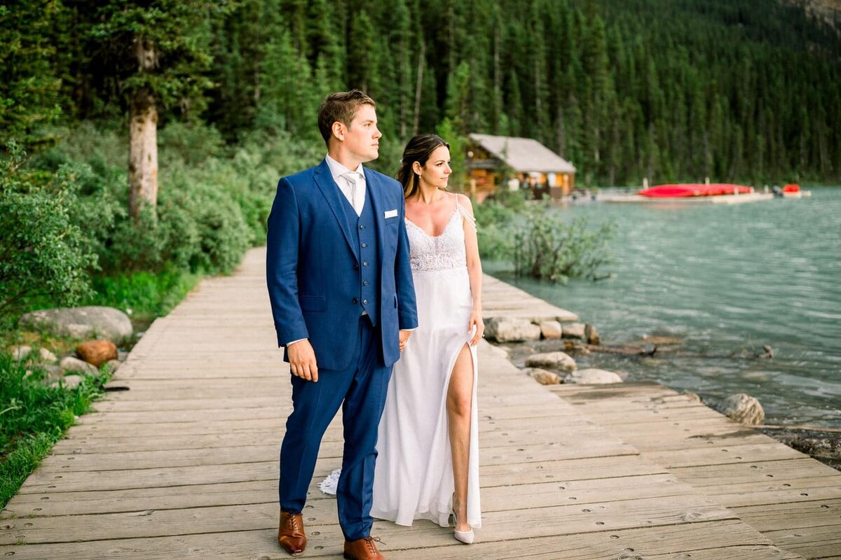 bride-and-groom-walking-hand-in-hand-at-Lake-Louise