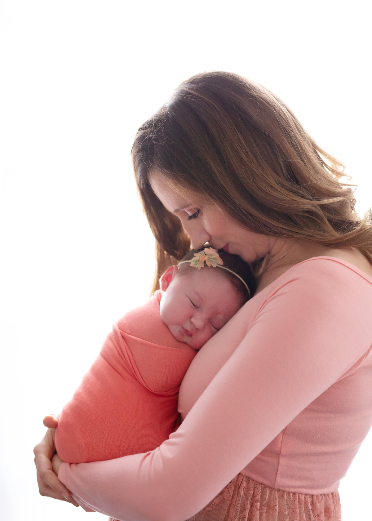 mom in pink cuddling her baby girl in yorktown photography studio