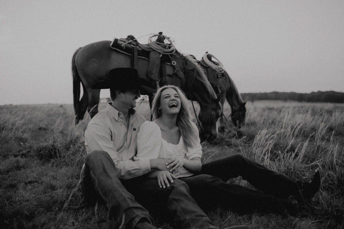 couple sitting with their horses laughing together