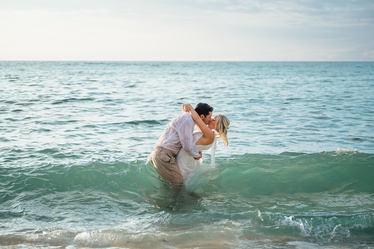 bride and groom in ocean after their wedding