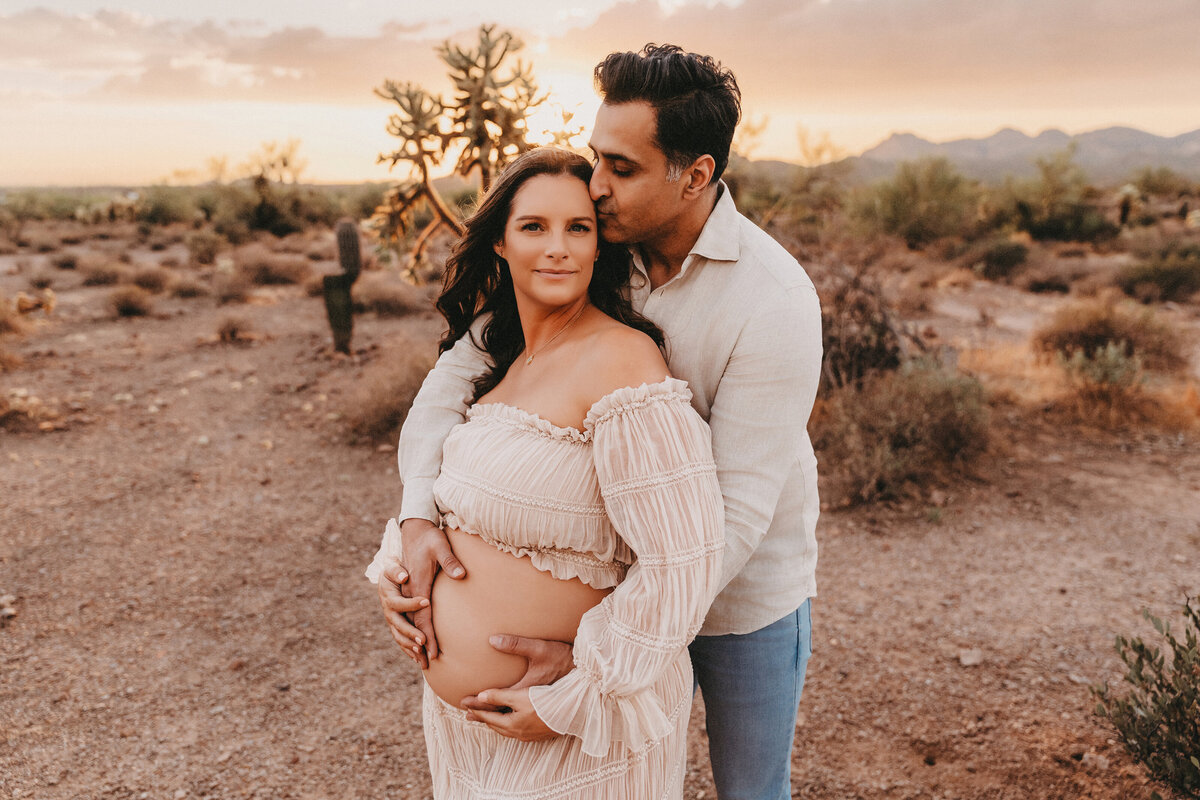 mixed race couple posing for maternity session at lost dutchman state park in arizona for maternity session