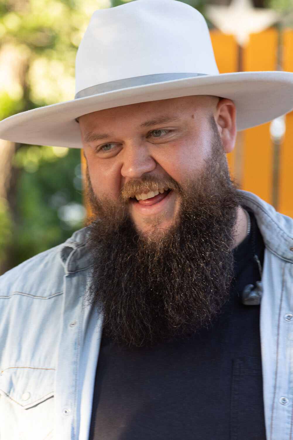 A man with a beard wearing a hat and smiling