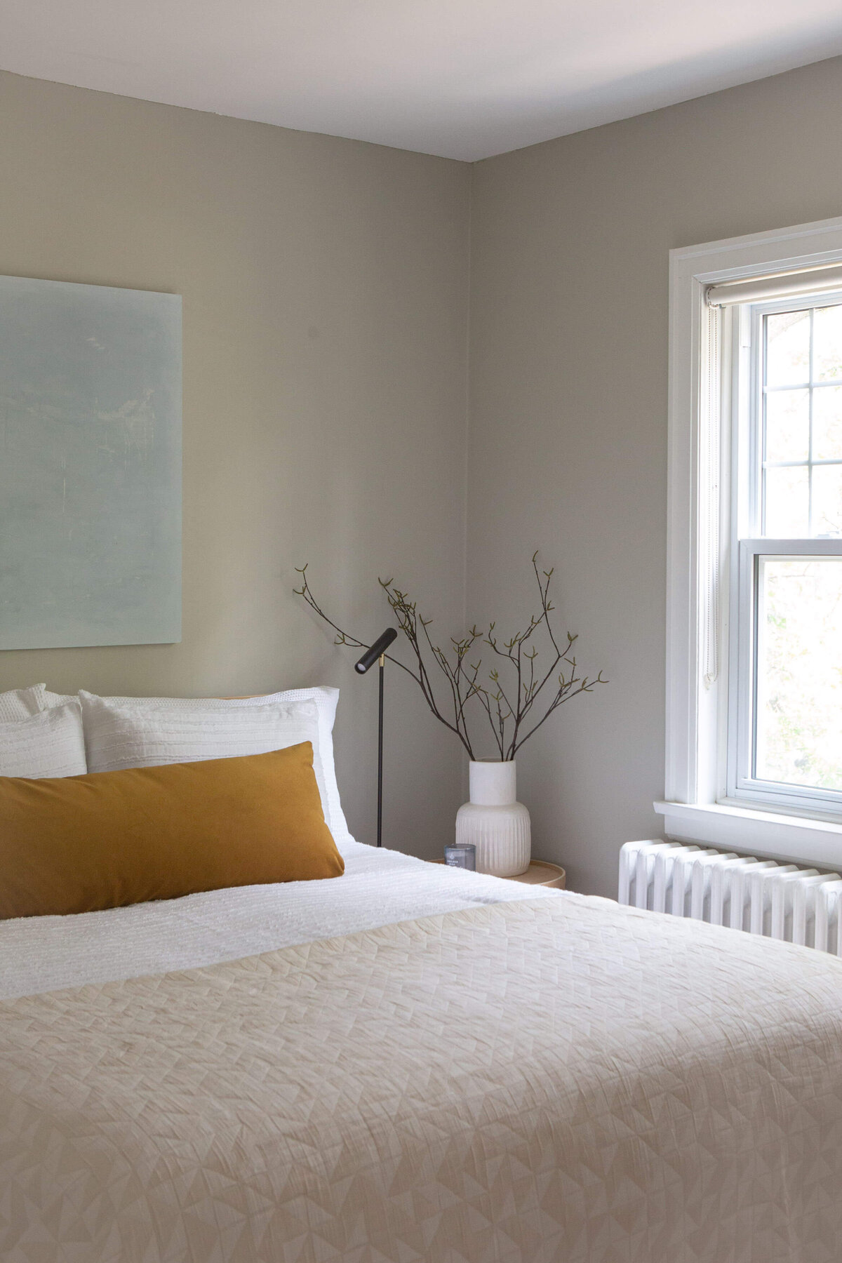 modern bedroom styled with long velvet lumbar pillow and modern art