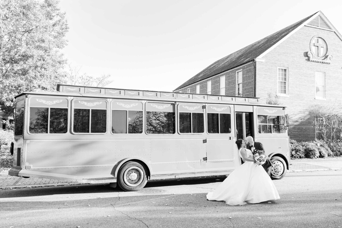 couple dipping and kissing in front of wedding trolley