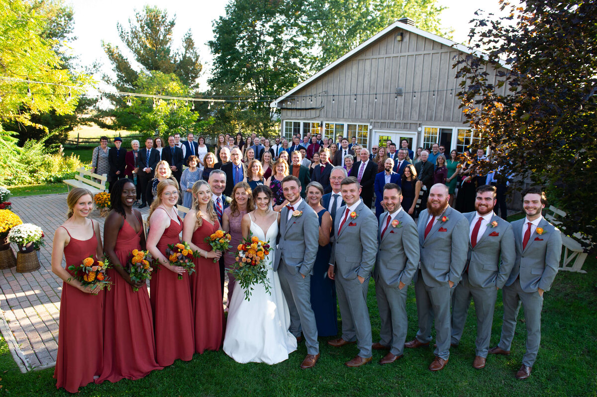 an Ottawa wedding photo of a bride, groom, wedding party and all their guests taken outside at the Garden House at Strathmere wedding venue
