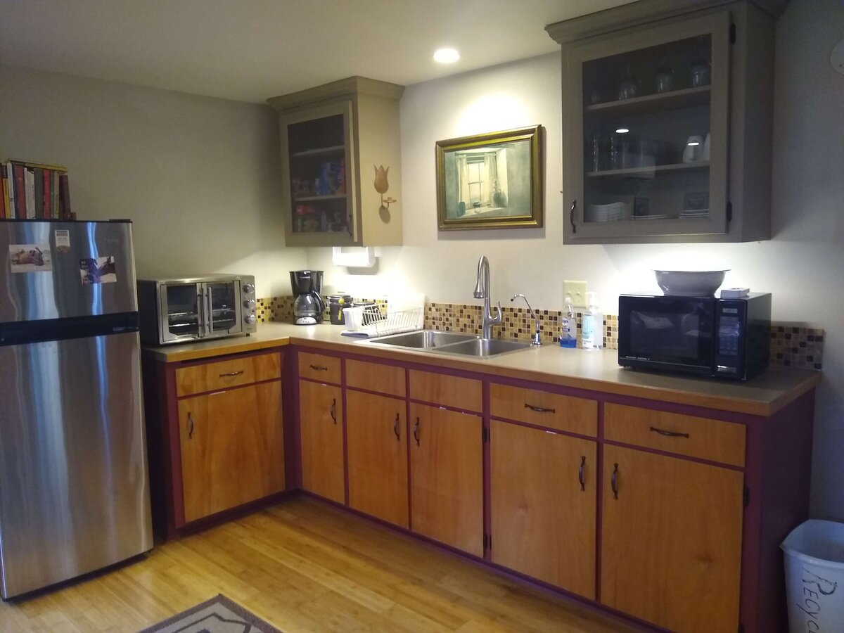 Photo of sink and kitchen cabinets in cottage.