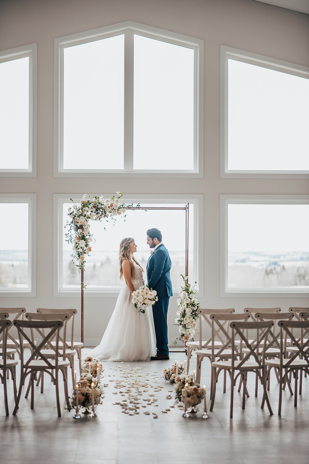 Stunning and romantic indoor ceremony at Tin Roof Event Centre, a modern wedding venue in Lacombe, Alberta, featured on the Brontë Bride Vendor Guide.