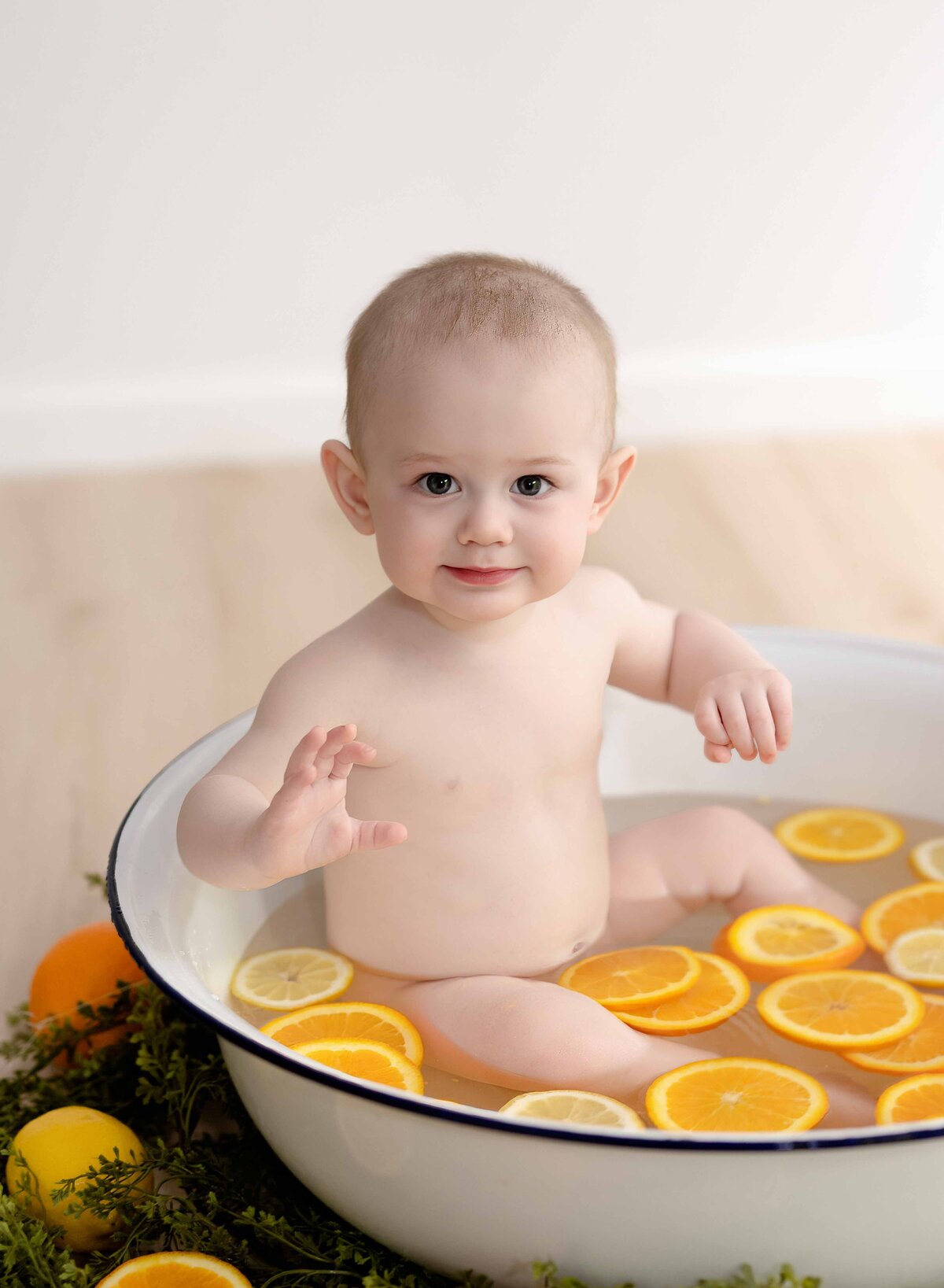 Bath sitting in fruit bath smiling. Baby photo by Jenni Nikki Photography at Atlanta photo studio.