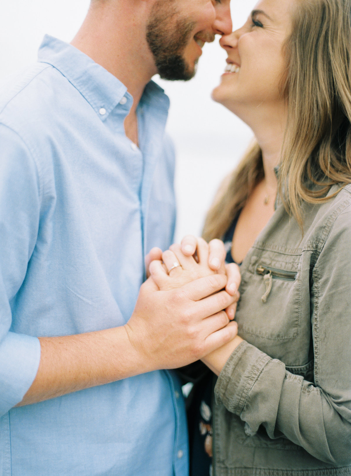 hands of couple face cuddling on film photography for engagement session