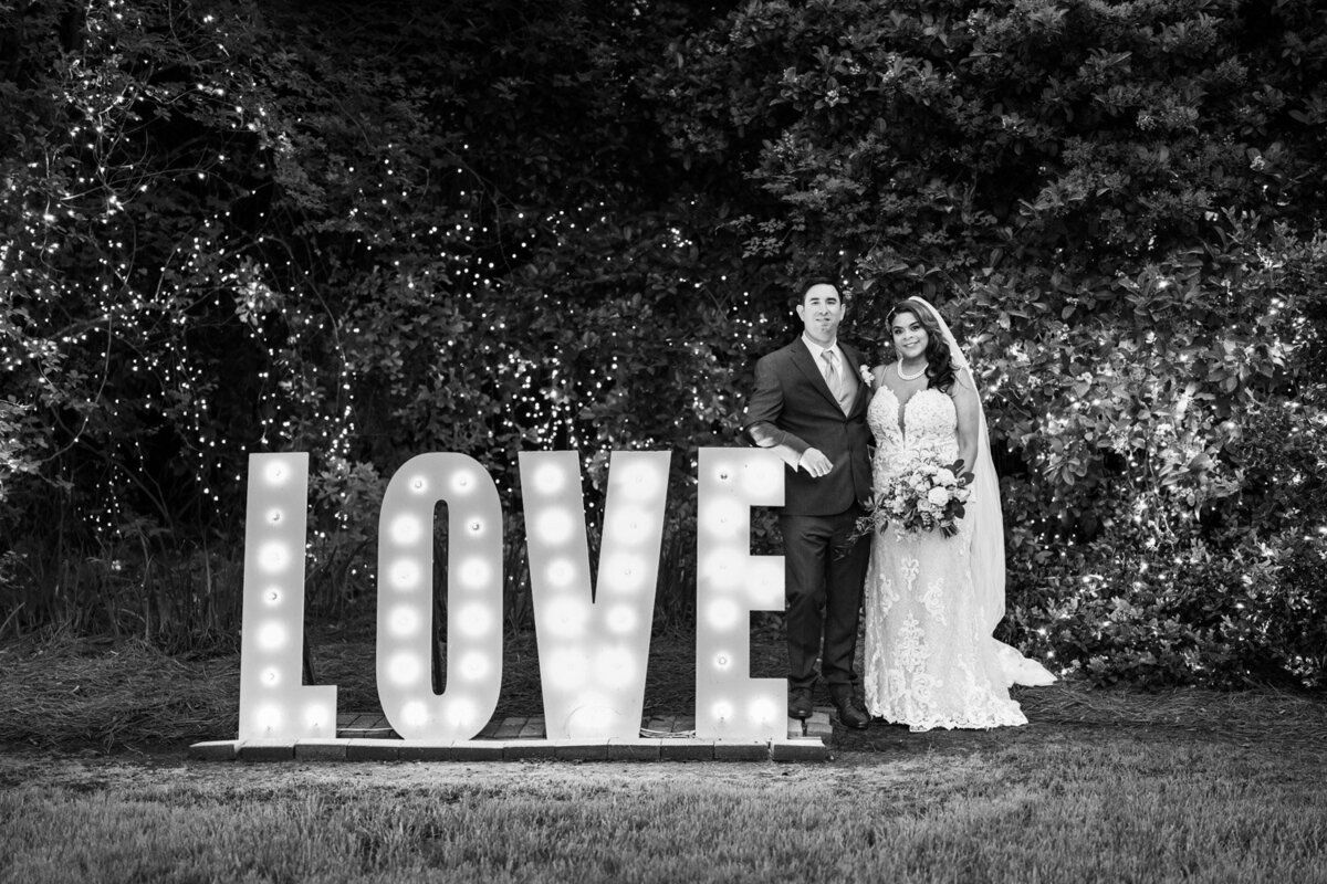 Couple standing by Southern Oaks love sign