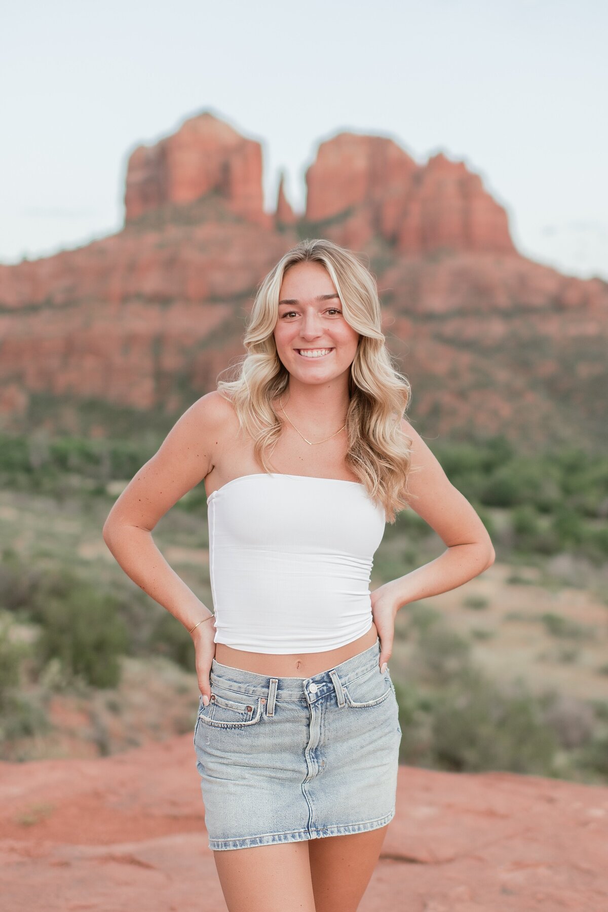 senior girl standing with cathedral rock behind her