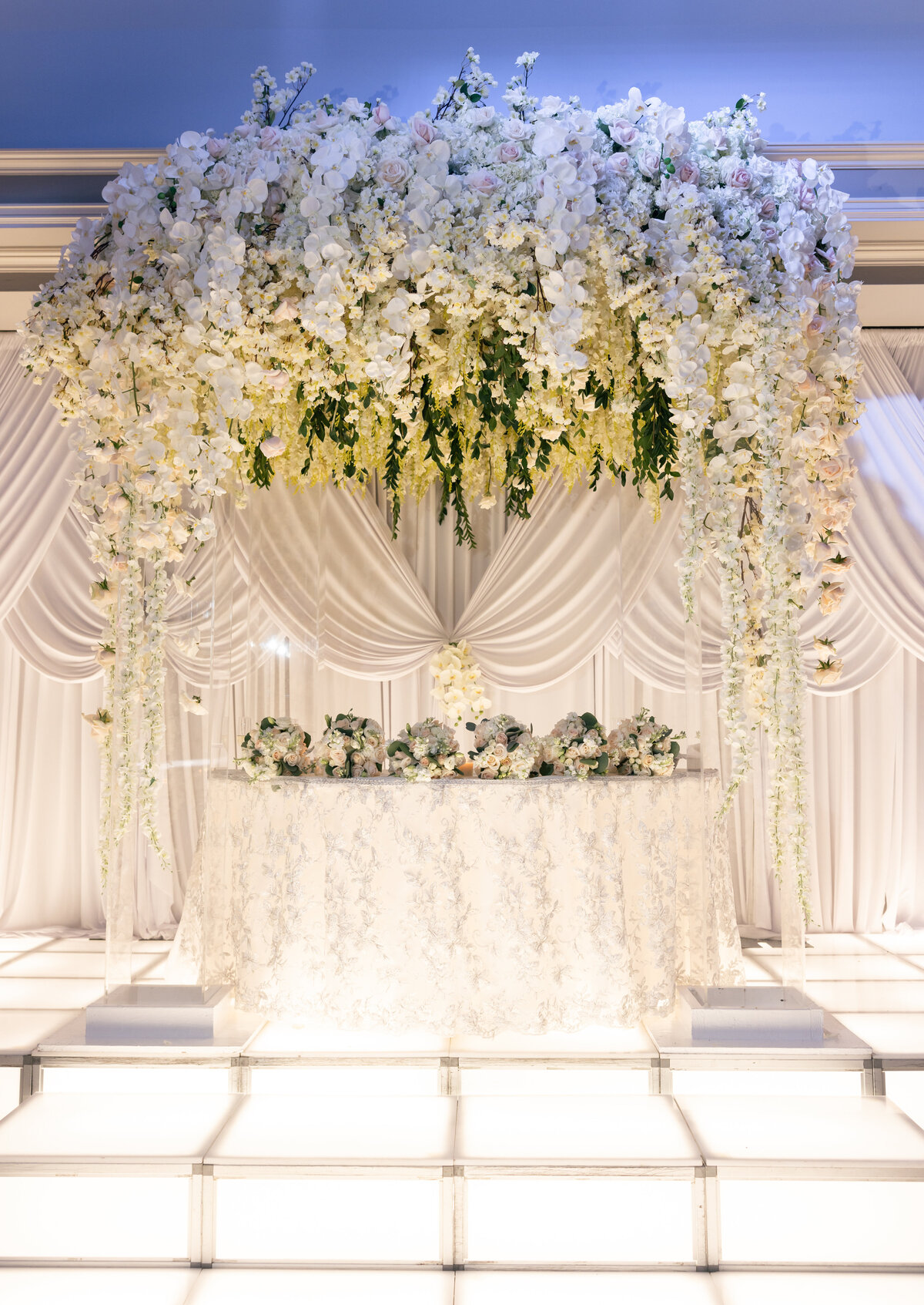 White elegant floral installation above bride and groom table at Hotel reception