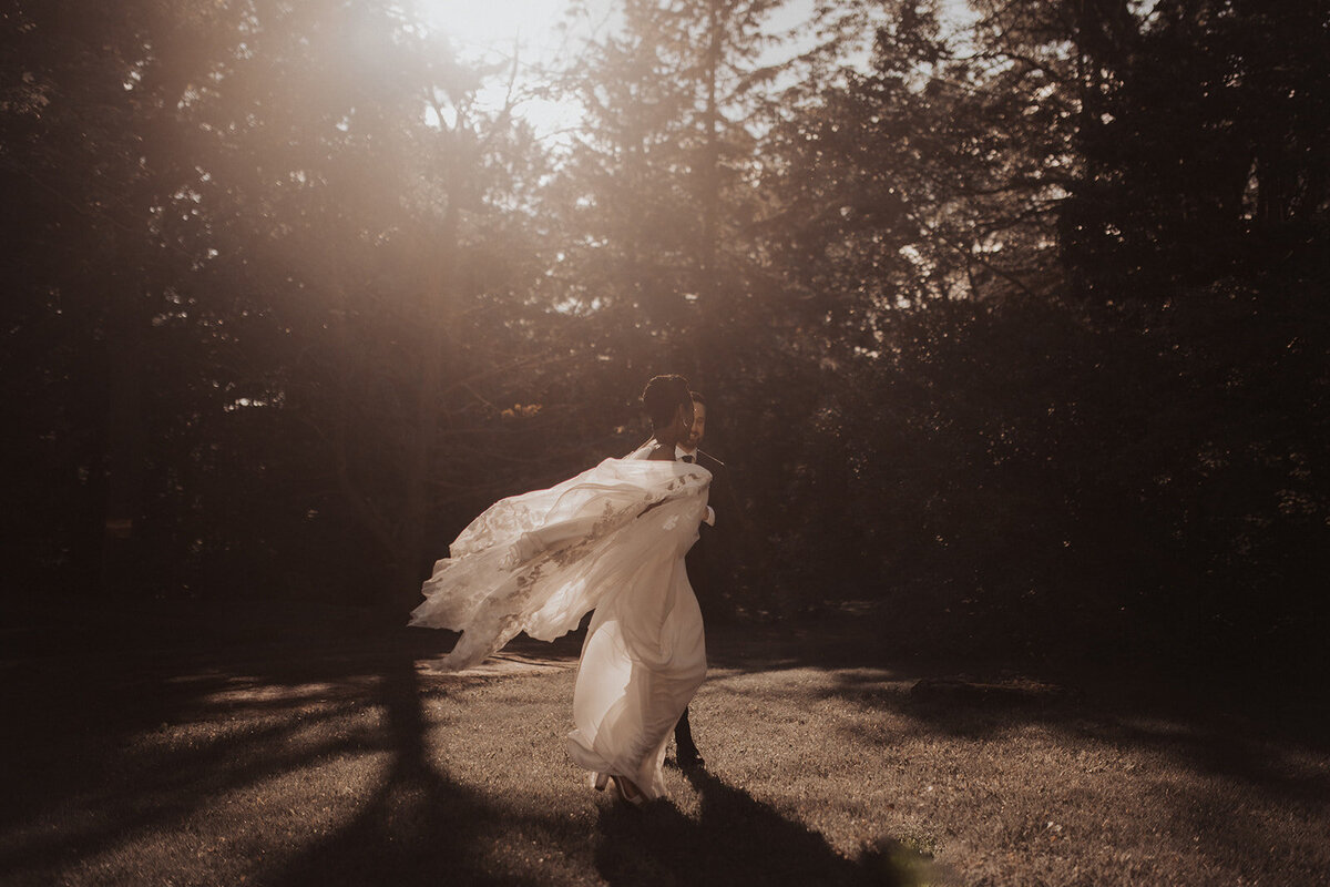 Bride running through forest, motion blur capturing the dynamic scene.