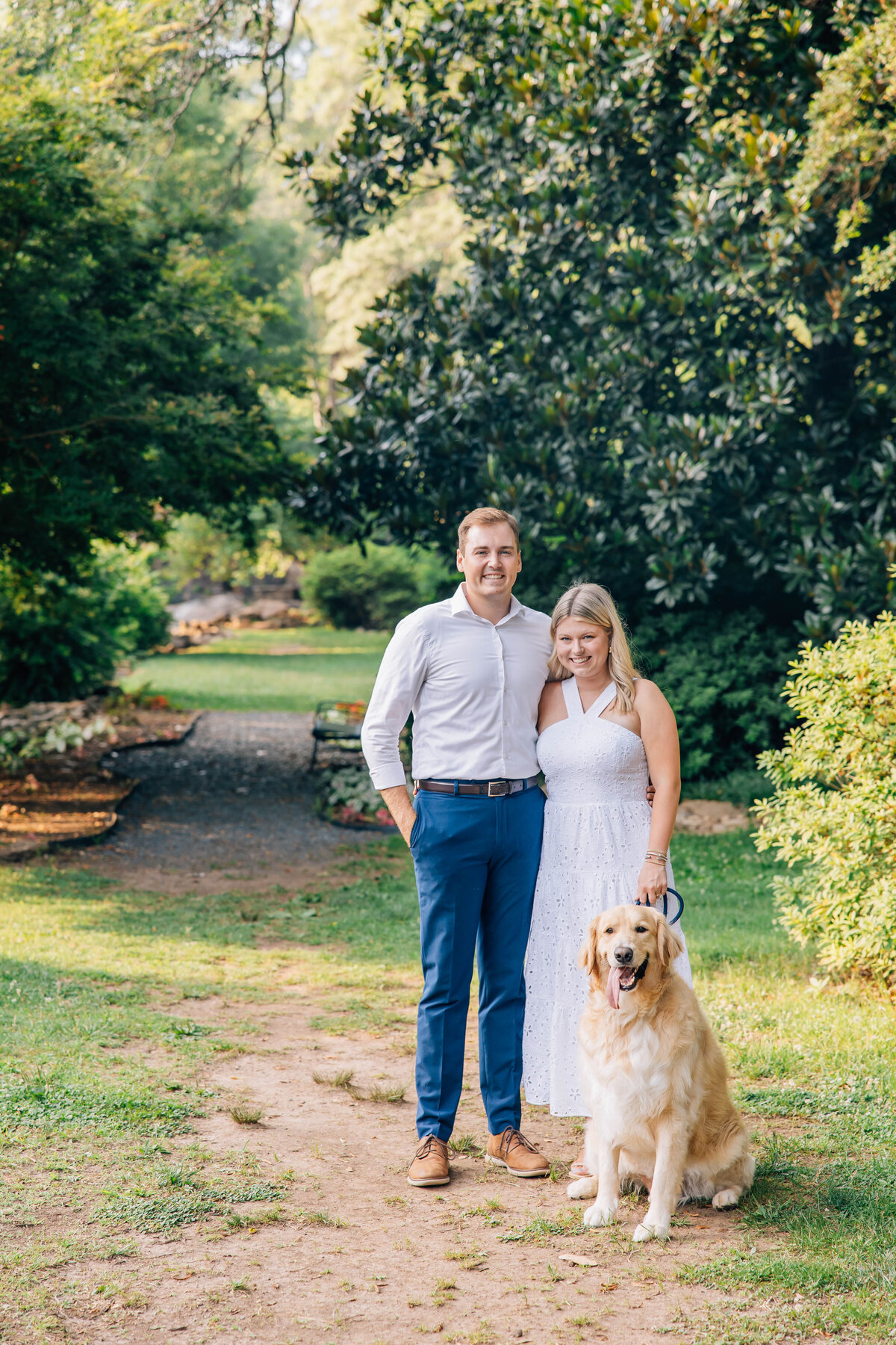 couple posing with their golden retriever for family photos