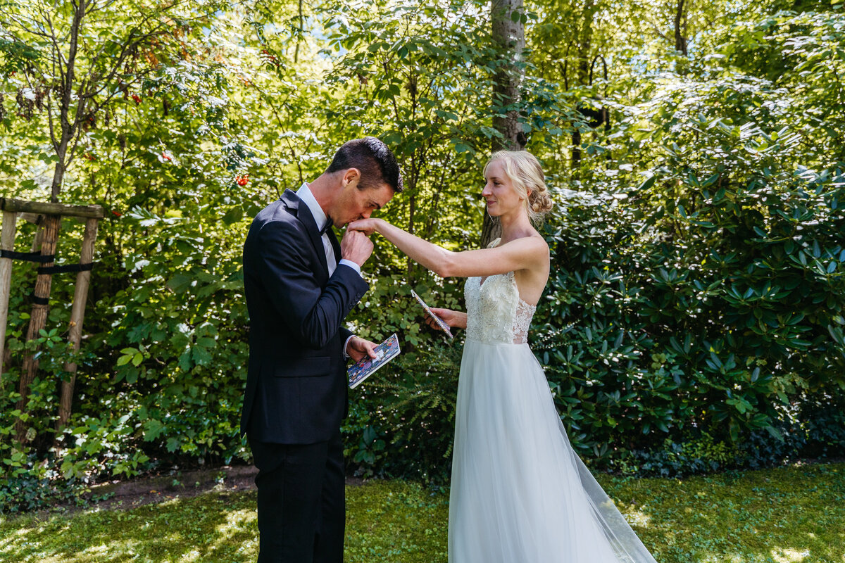 Bride walking toward groom for first look in garden