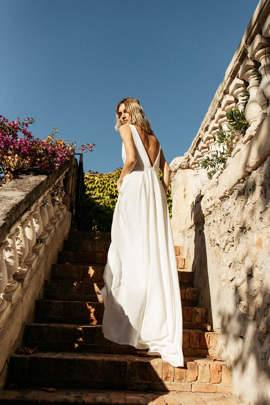 Deep v back wedding dress in silk, bride on steps of a villa in France