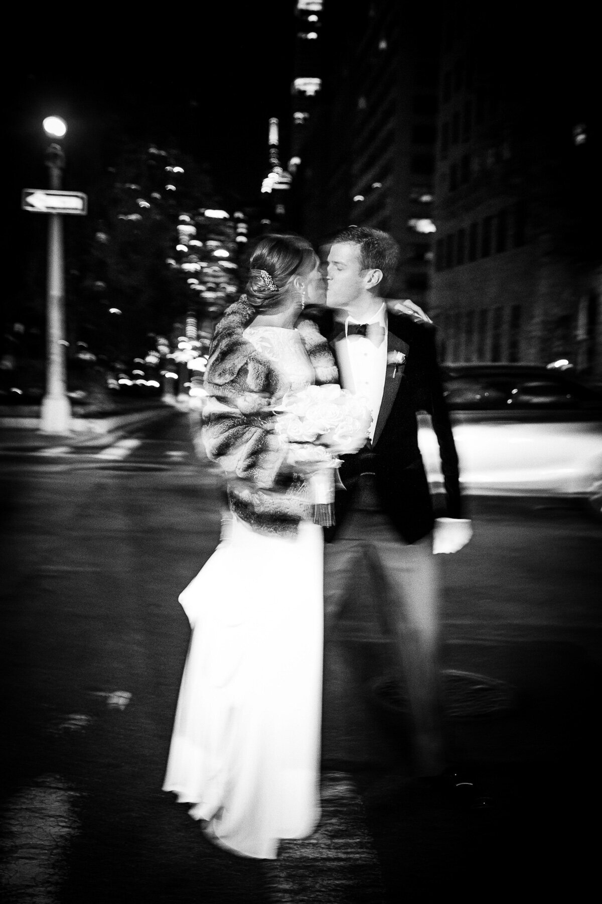 A couple kiss on their wedding day on Park Avenue at night