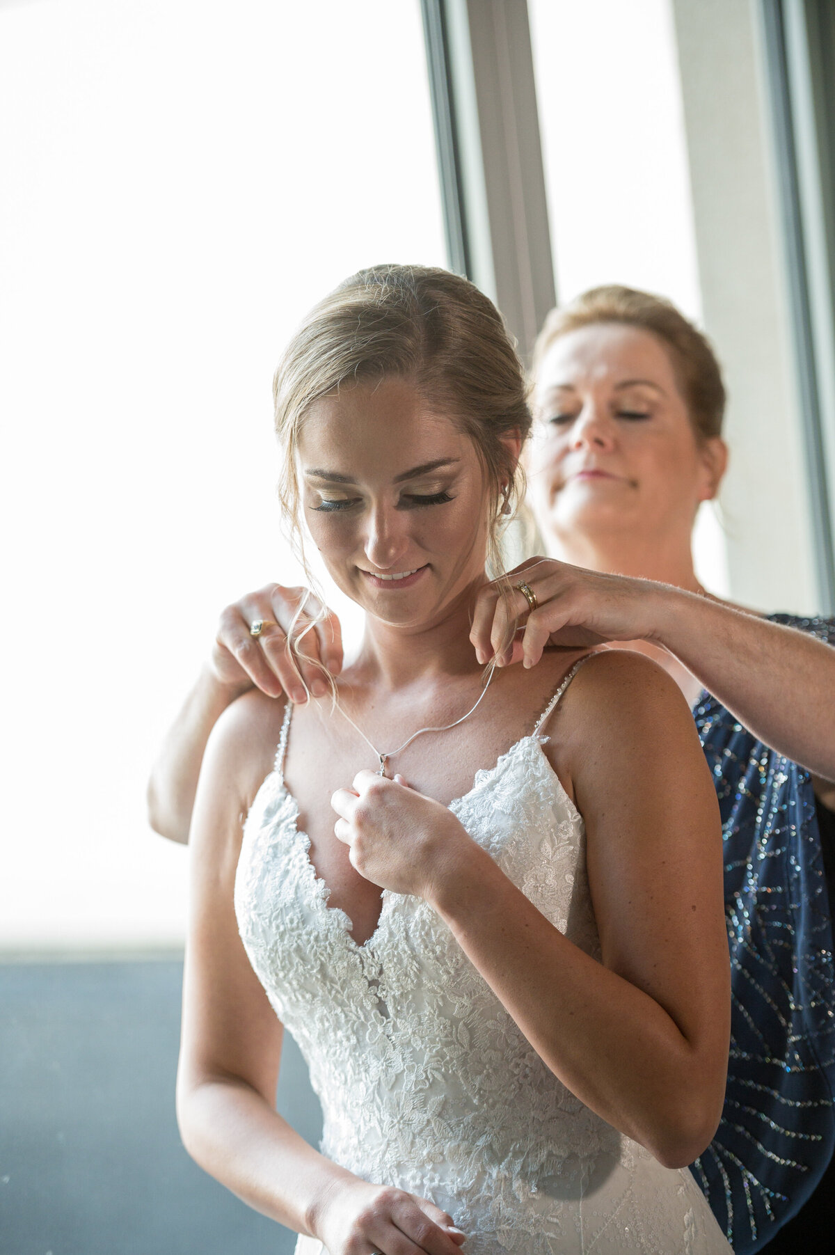 Mother of bride putting on necklace.