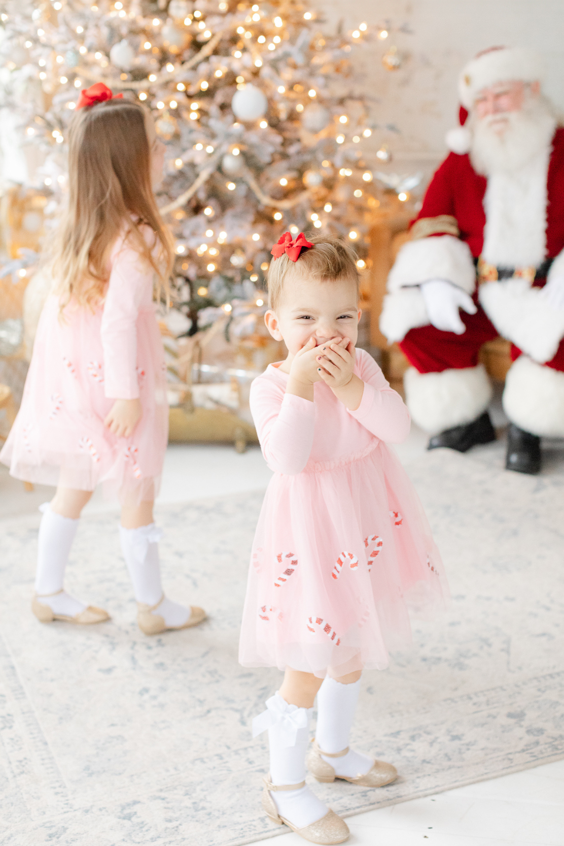 young girl looks at camera with surprise and happiness when meeting santa claus