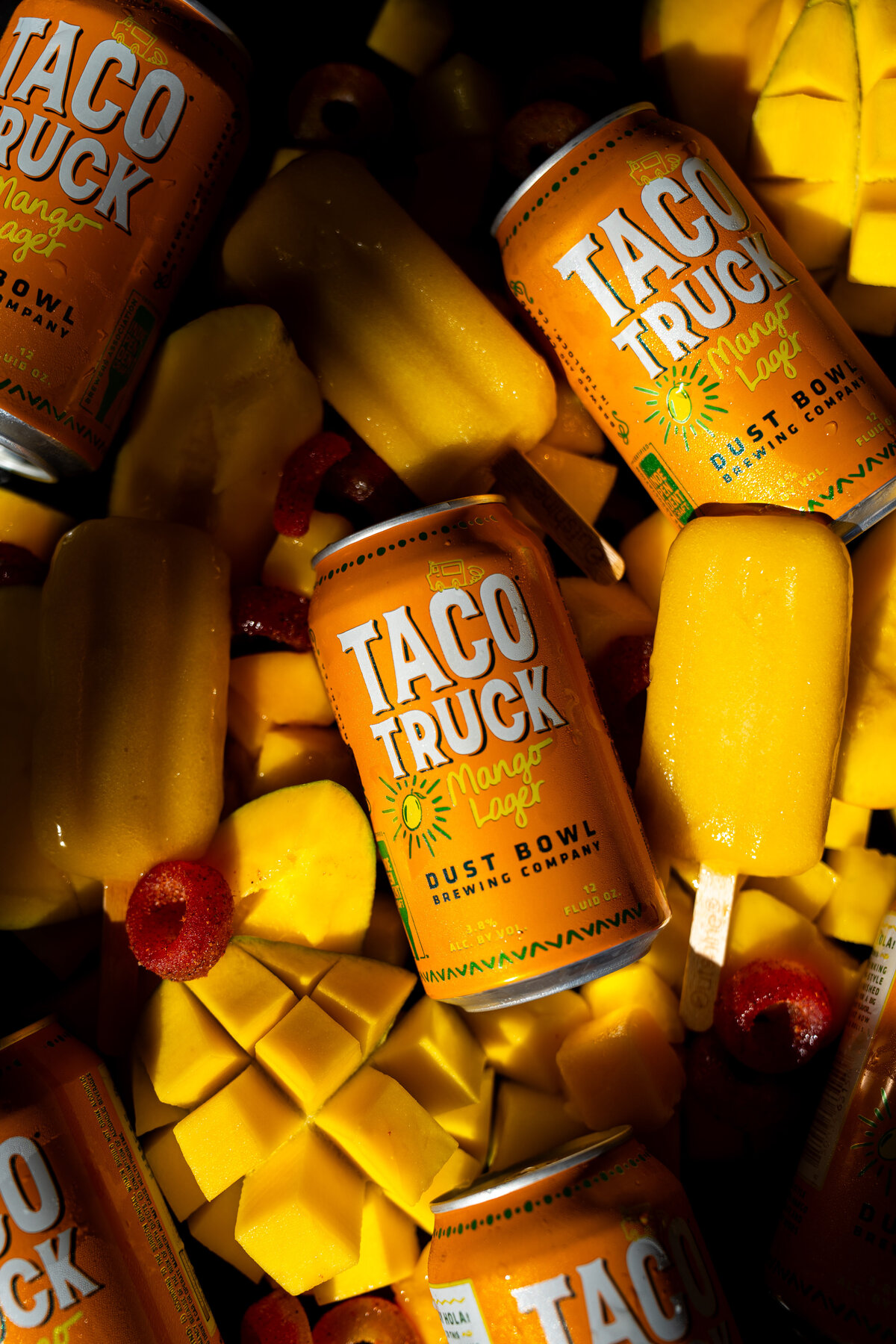 Product photography showcasing the new taco truck mango surrounded by mango chunks and mango popsicles