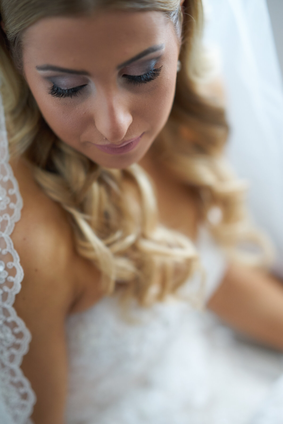 A close-up of a bride highlights her radiant face, elegant makeup, and intricate bridal hairstyle. This image captures the intimate details and beauty of the bride, showcasing the sophistication and emotional depth of our bridal portrait photography.