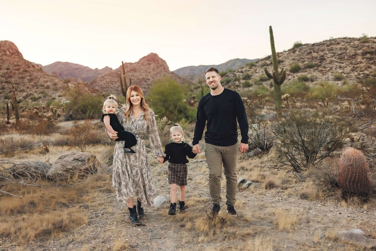Colorado family walking together in the Arizona desert with cactus around them