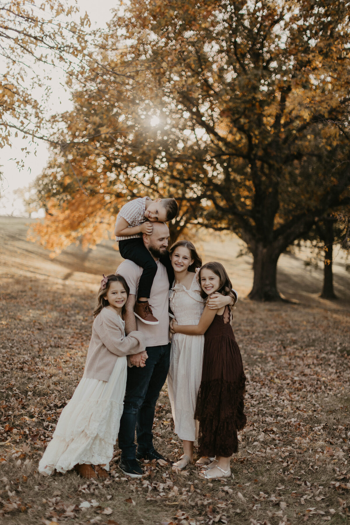 Dad surrounded by his 4 children, youngest on his shoulders. 