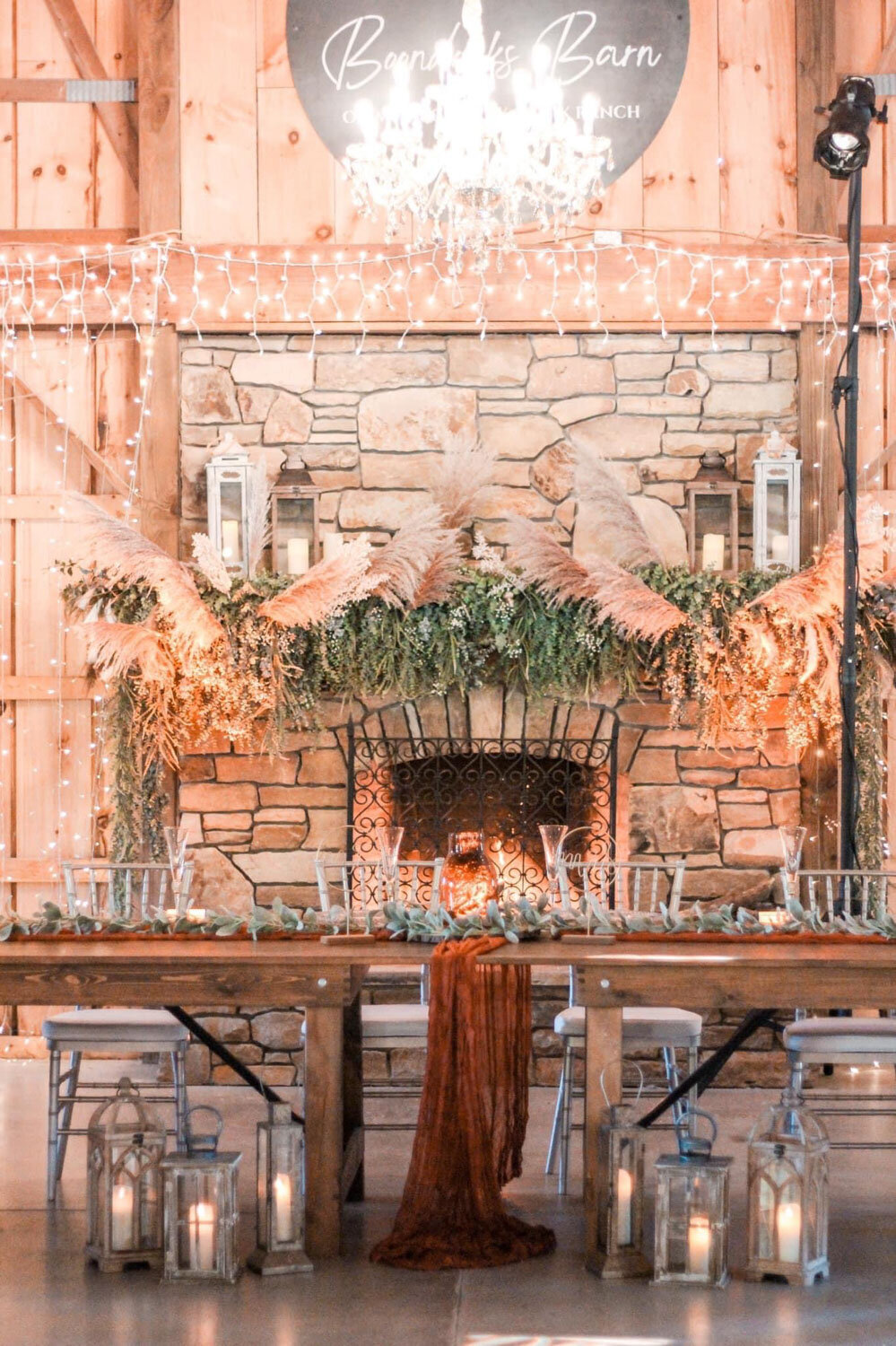 Stone fireplace decorated with pampas grass and lanterns