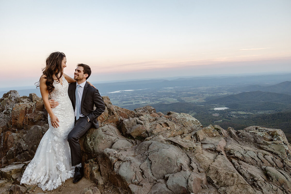 A married couple sits at Stonyman summit during their sunrise elopement