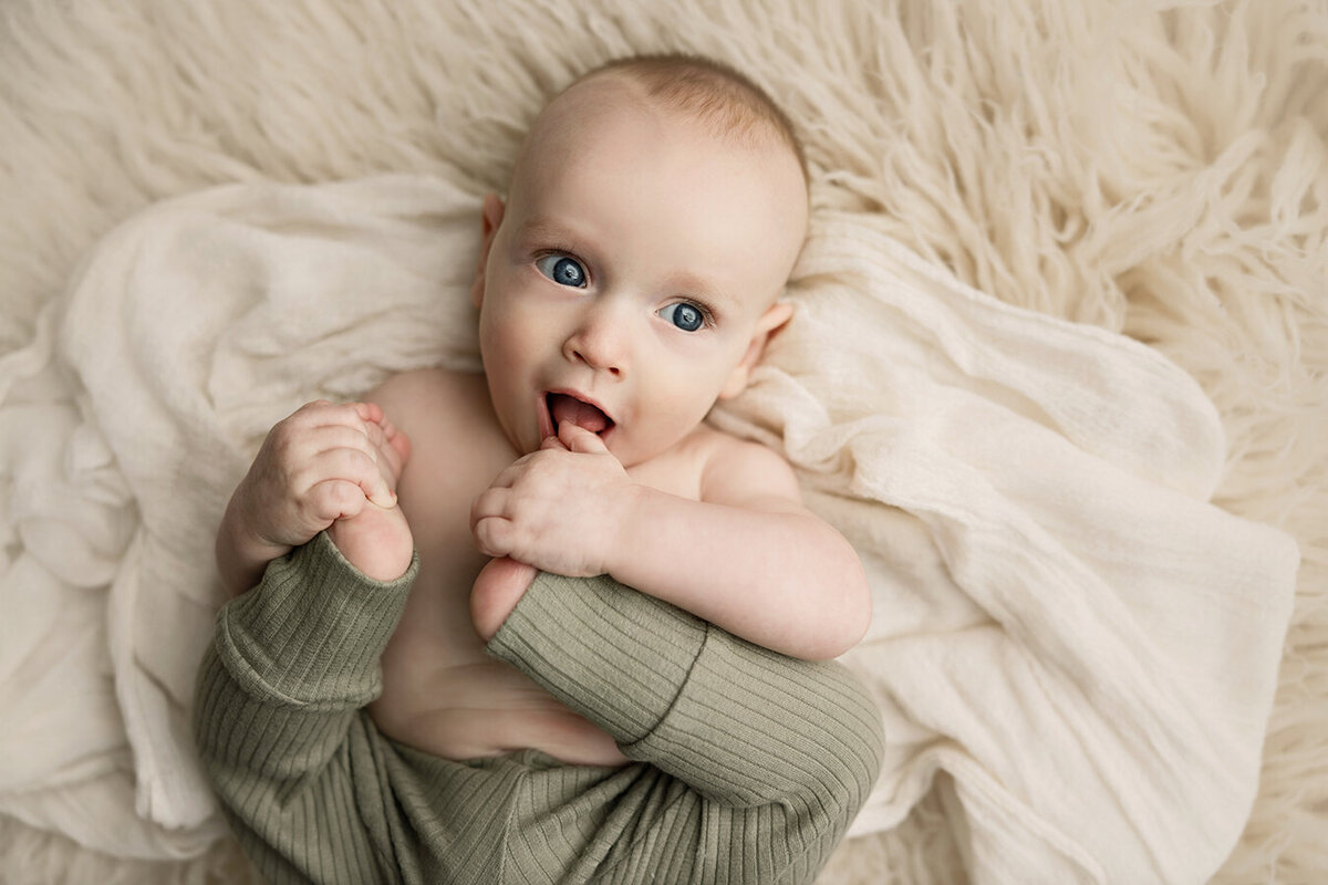 Six month old Fort Collins baby boy putting his toes in his mouth