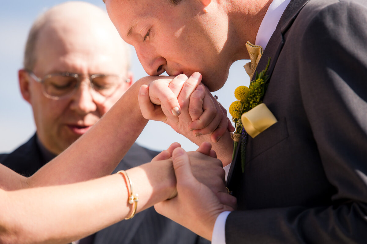 The groom gives his bride's hand a kiss during their wedding ceremony at Schweitzer Mountain Resort in Sandpoint, Idaho.