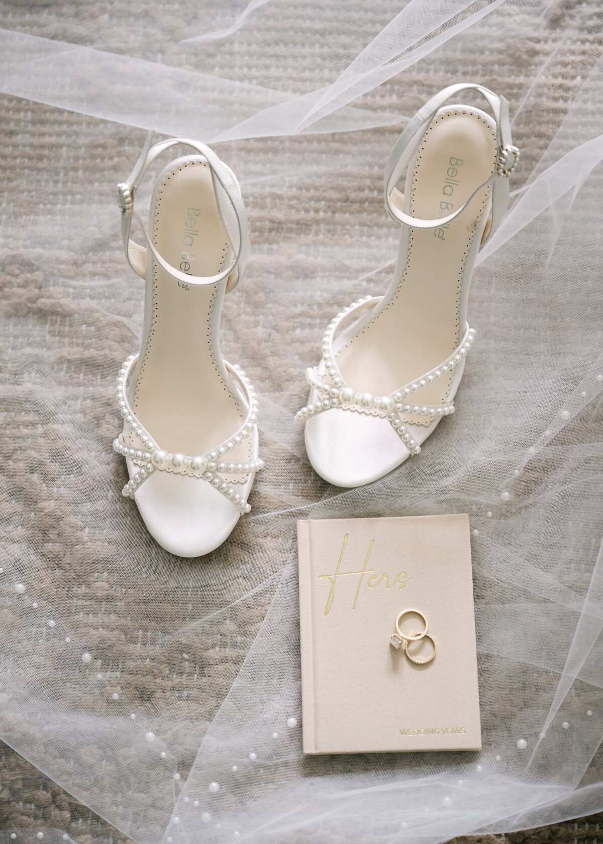 wedding details white shoes, veil, vow book, and rings