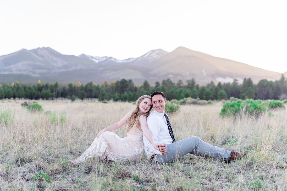 eloped bride and groom sit back to back and hold hands in flagstaff arizona