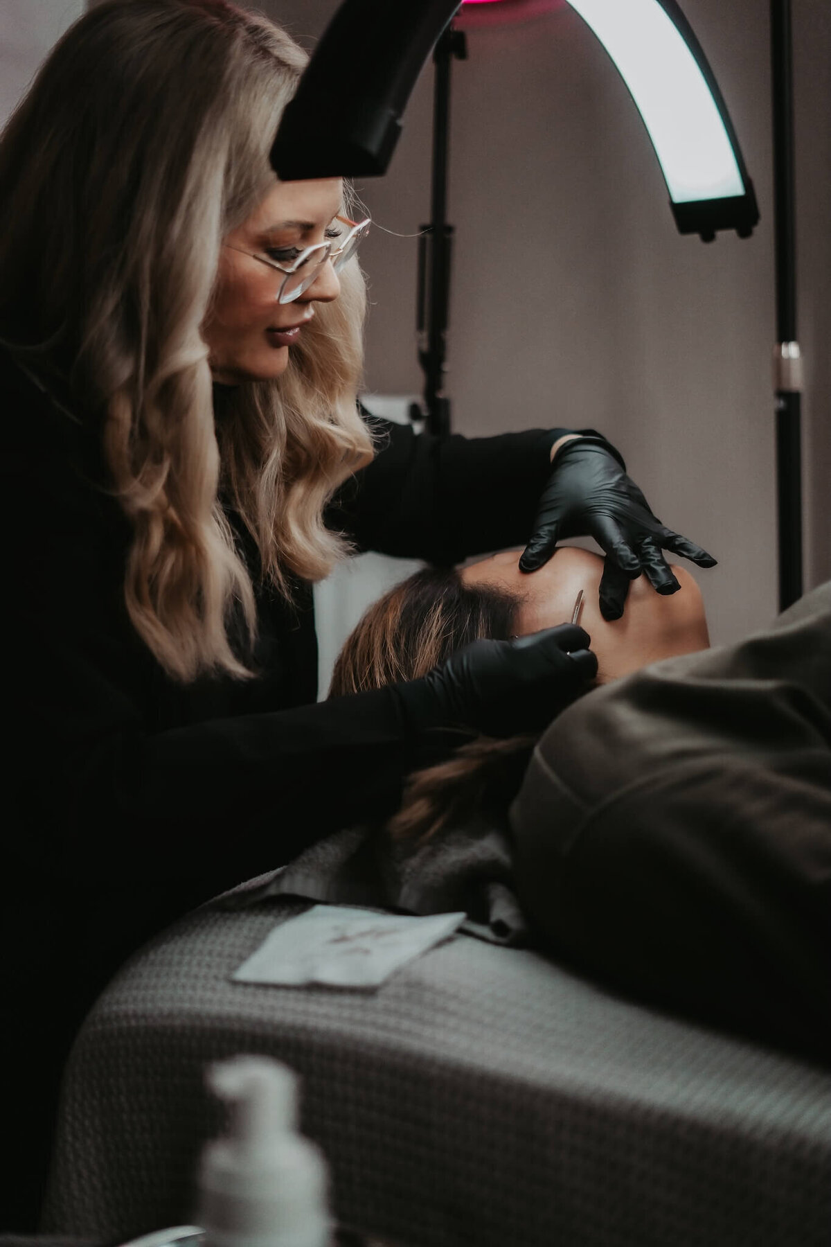 skincare specialist dermaplaning a client's face in her Appleton studio