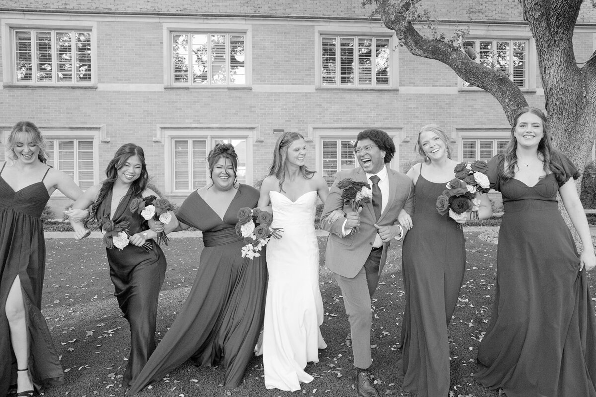 High-energy wedding party cheering in celebratory black and white portrait at San Antonio venue