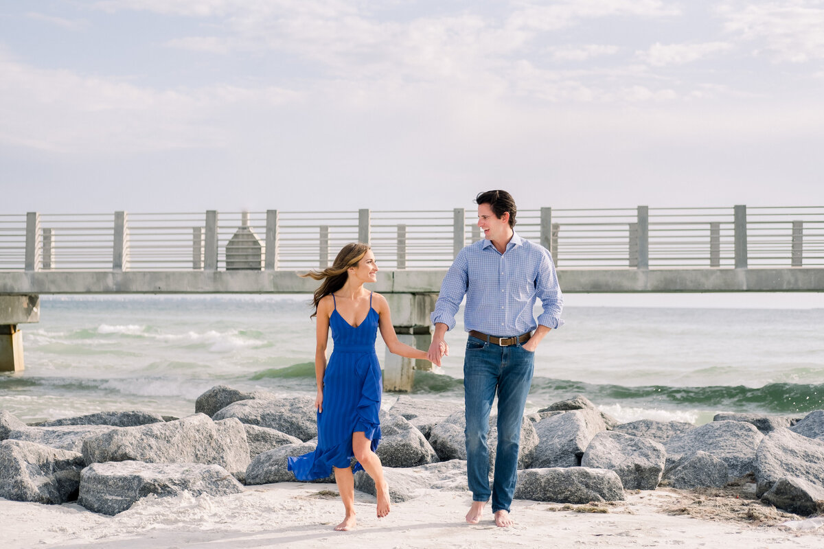 Engaged couple walk on beach during Fort Desoto engagement session