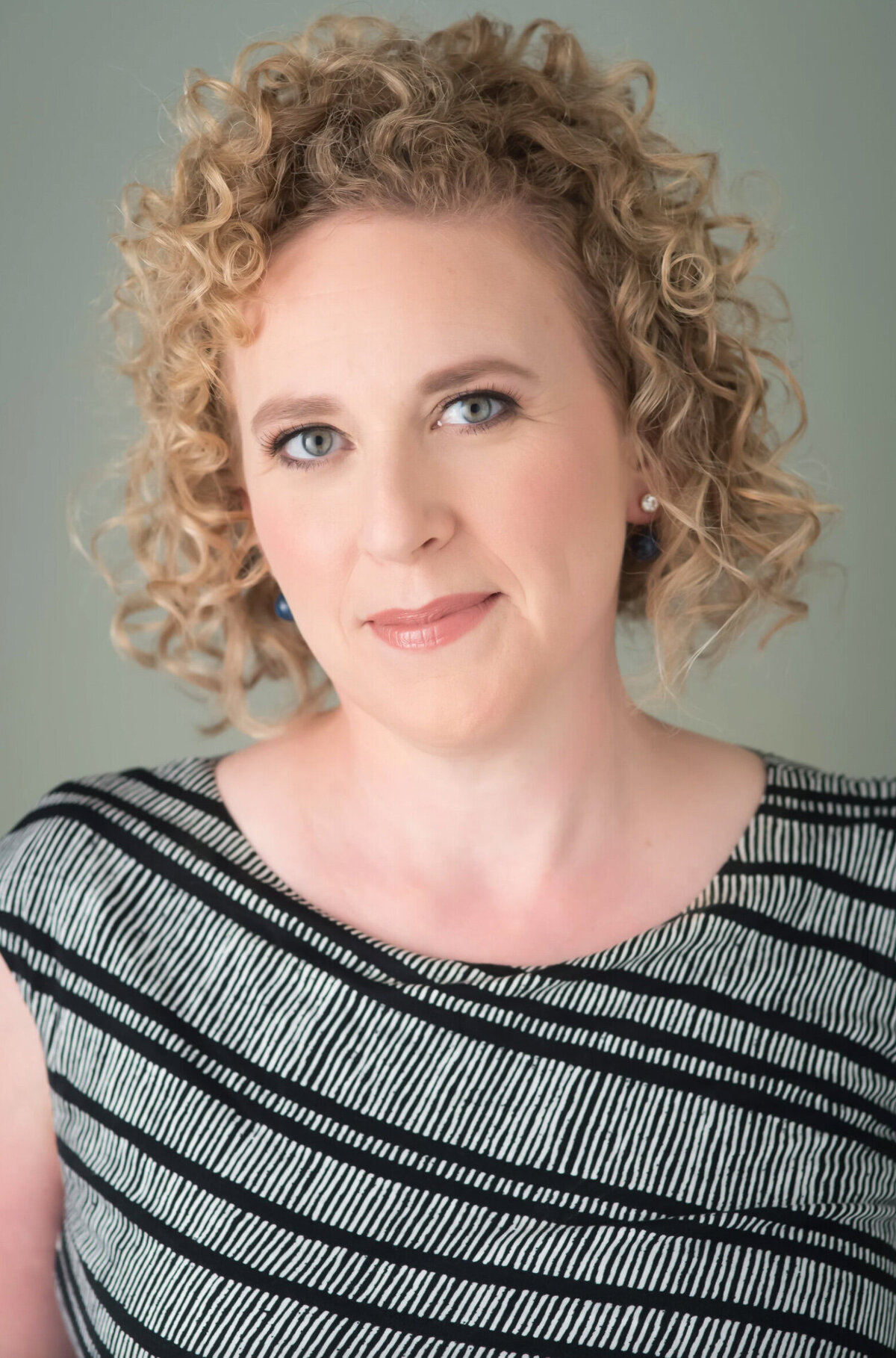 Woman with curly hair posing for a professional business headshot in New Jersey