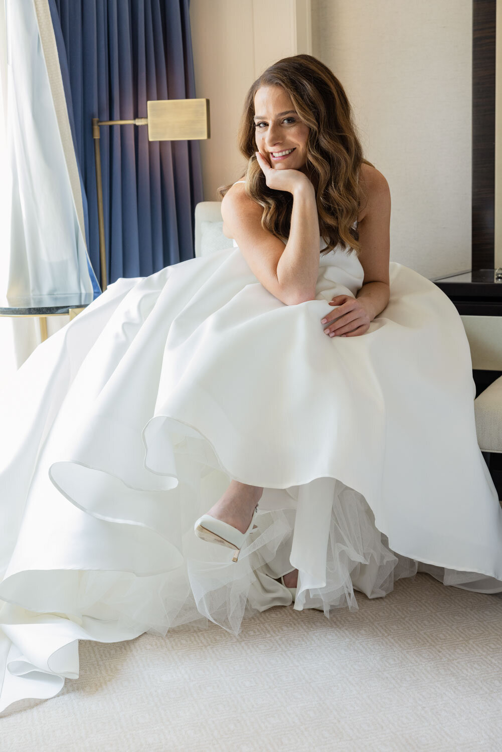 A woman in a white wedding dress is sitting on a chair