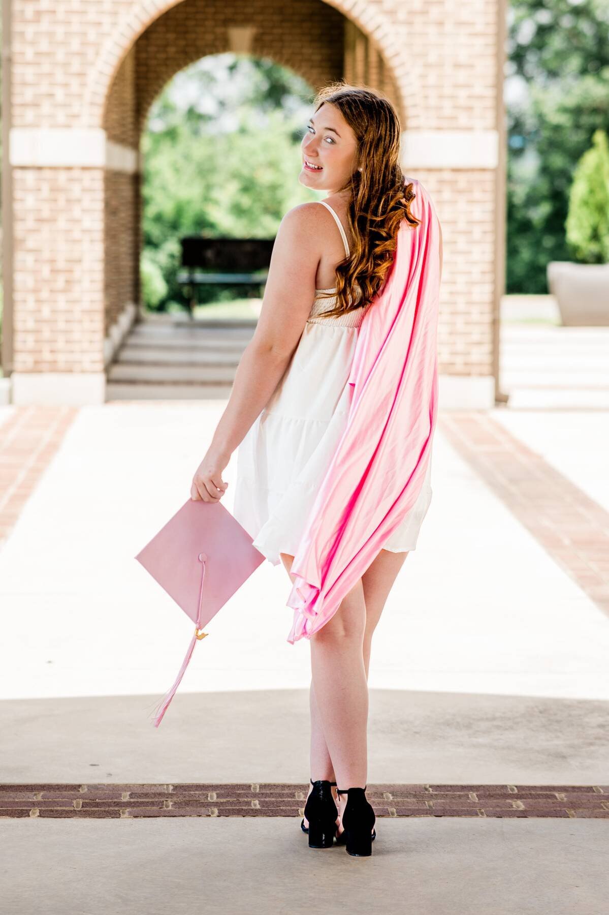 Girl walking away with graduation cap