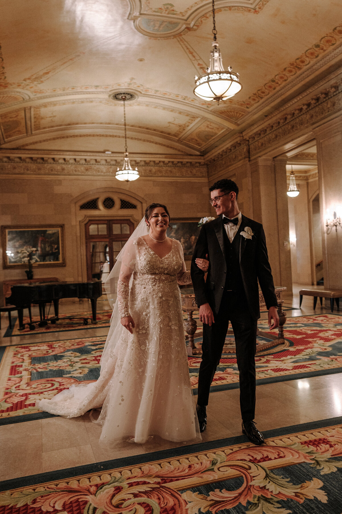 lovebirds walk through the fairmont with stunning architecture surrounding them